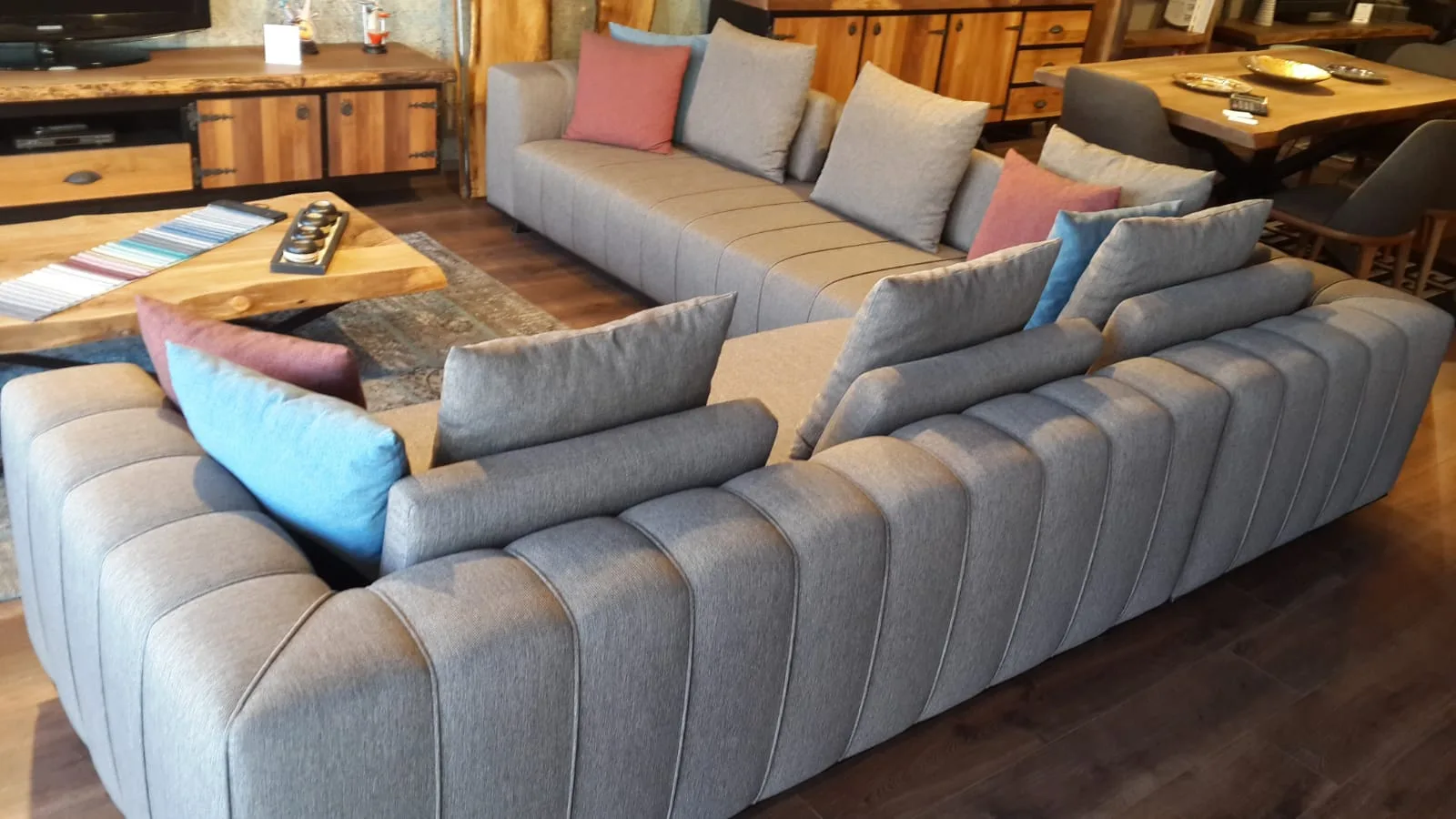 Gri kanallı dikişli modüler oturma grubu; üçlü kanepe ve karşılıklı yerleştirilen modüller