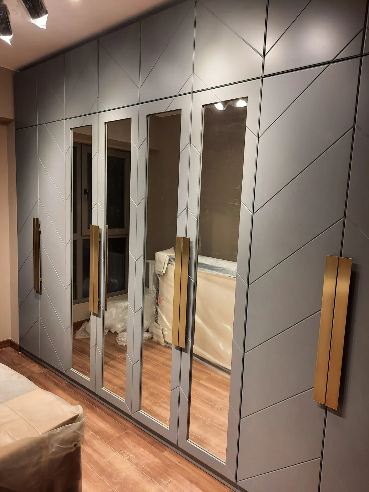 Gri kapaklı, aynalı modüllü ve uzun kulplu ölçüye özel gardırop