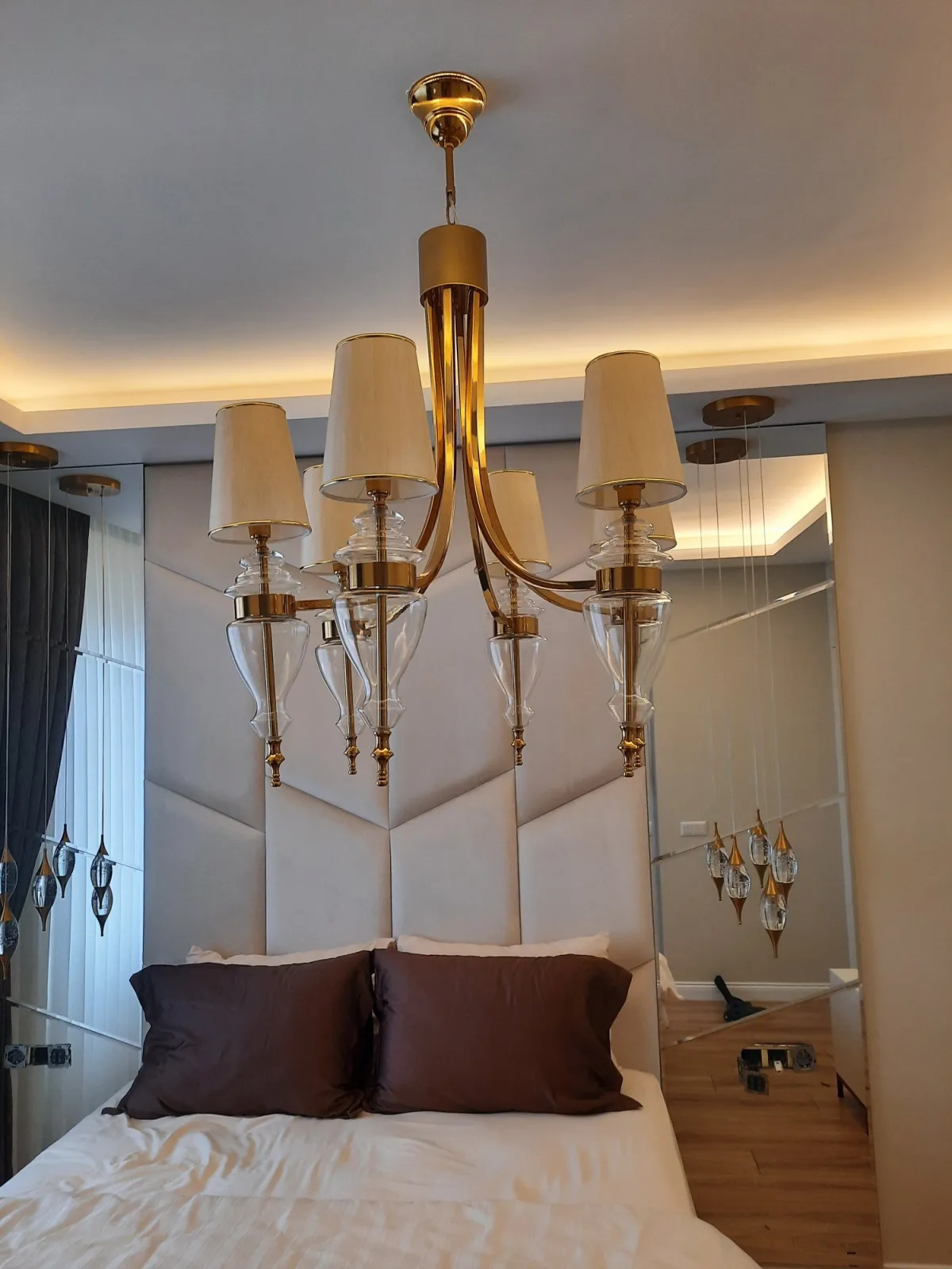 Ölçüye özel yatak odası; geometrik dikişli beyaz kapitone başlık duvarı, altın avize ve aynalı yan panel